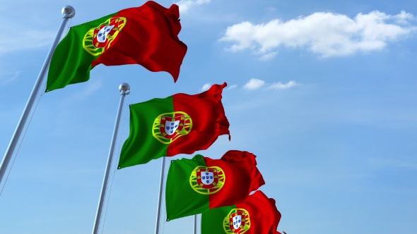 Multiple Waving Flags of Portugal Against the Blue Sky