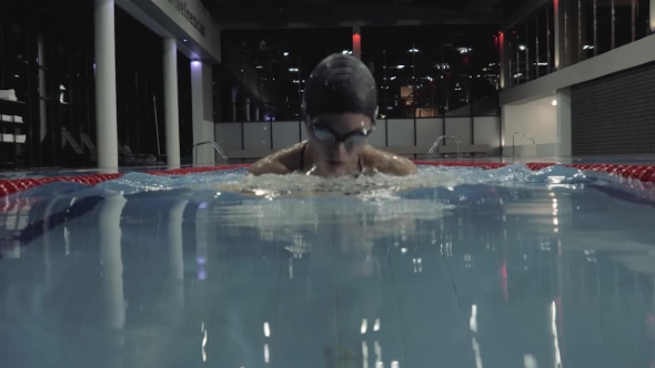 Sports Woman Floating Breaststroke Style in Blue Water Swimming Pool