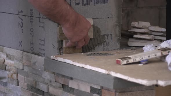 Male Hands Setting Stacked Stone Tiles Close Up