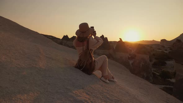 Woman Photographing the Valley of the Monks at Sunset