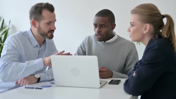 Business People Arguing While Using Laptop in Office