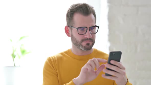 Portrait of Man Reacting to Loss on Smartphone