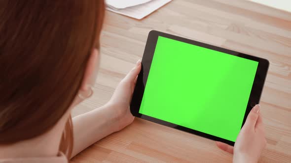 Close Up Shot of Hands Holding a Tablet Computer with Green Mock Up Screen