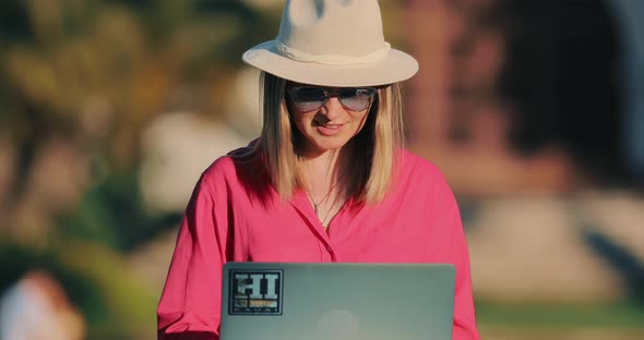 Attractive Woman Checking Her Email and Deciding on the Online Offers in Park