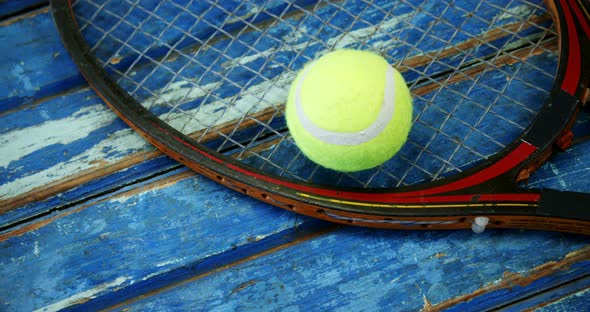 Tennis ball and racket on wooden plank 4k