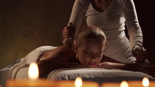 Young, healthy and beautiful woman gets massage therapy in the spa salon.