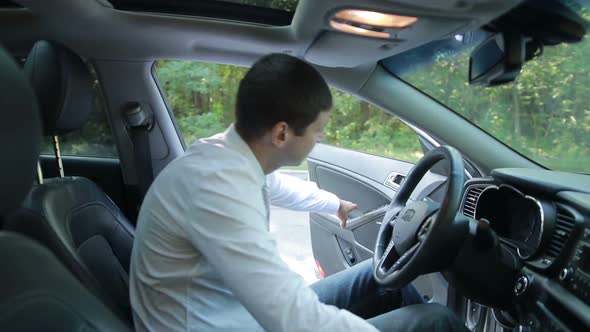 Serious Businessman Getting Into Luxury Car