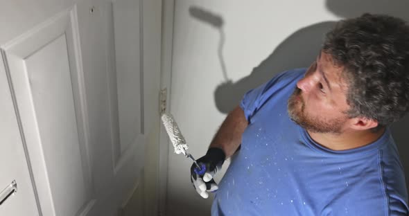 Handyman Home Renovation Painter of Painting Doors Trim Using Hand Roller Painting