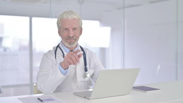 Cheerful Old Senior Doctor Pointing Finger at Camera