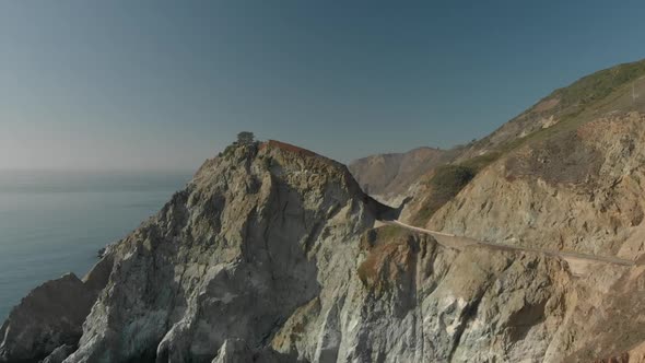 Aerial Push In of Tree on Rock on California Coast Highway One