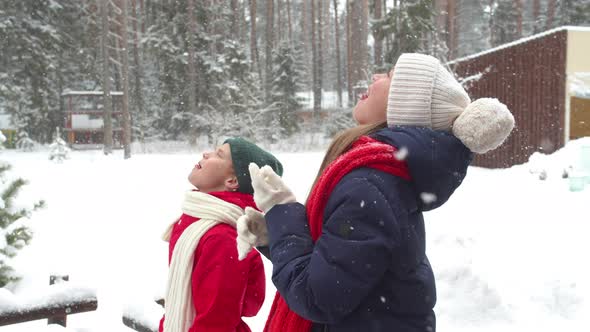 Children Catch Snowflakes in Their Mouths. Slowmotion