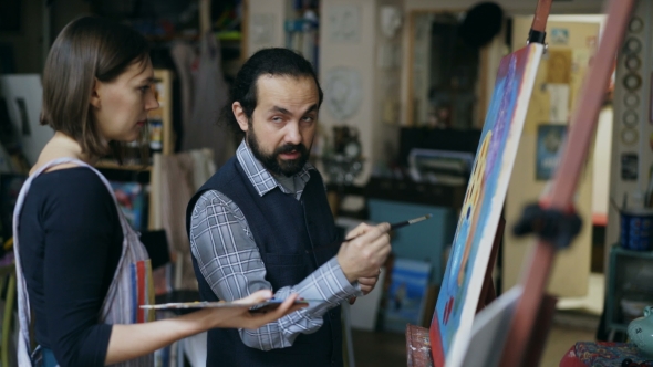 Skilled Artist Man Teaching Young Girl To Draw Paintings and Explaining the Basics of Light in Art