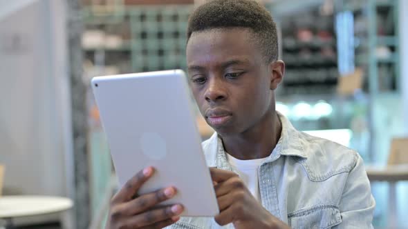 Portrait of Attractive Young African Man Using Digital Tablet