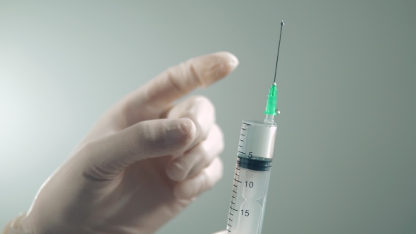 Syringe for Injection in the Hands of a Doctor in Gloves