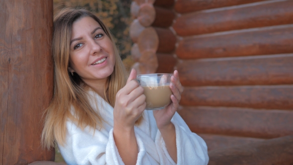 Of Woman In Bathrobe Drinking Hot Coffee In The Veranda Of Wooden House