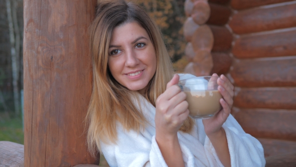 Of Woman In Bathrobe Drinking Hot Coffee On The Veranda Of Wooden House