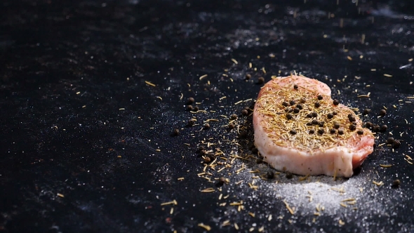 Seasoning a Delicious and Healthy Piece of Raw Pork Meat with Pepper, Salt and Spices