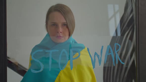 Sad Woman Wrapped in Ukrainian Flag Wishing for Peace and Stop War in Ukraine