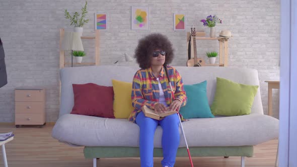 African American Woman with an Afro Hairstyle Visually Impaired Reading a Book with Your Fingers