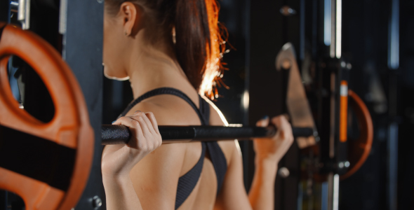 Woman Training with Barbell Sport Simulator in Gym Workout