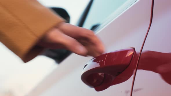 A Woman Brings Her Hand to the Red Car Door Handle and Opens It Side Mirror Unfolding