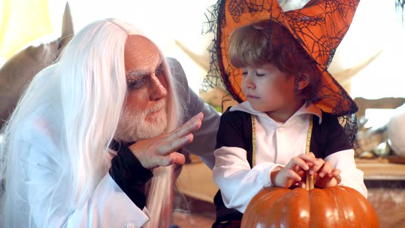 Happy Grandfather and Child Boy in Halloween Costume. Scary Stories. Man and Boy Scare Guests