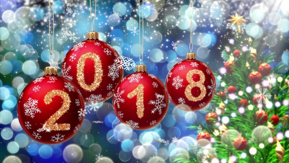 Red Balls with Numbers 2018 Hanging on the Background of a Blue Bokeh and a Rotating Christmas Tree