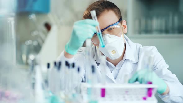 A Young Man Doing an Experiment in a Chemical Laboratory