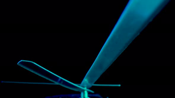 Bottom View of Clock Hands Illuminated By Blue Light Rotating on Isolated Black Studio Background