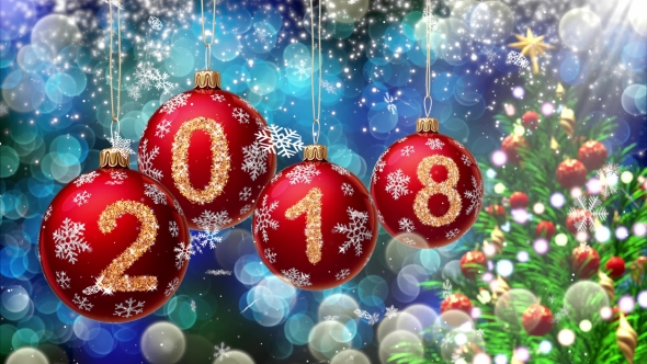 Red Balls with Numbers 2018 Hanging on the Background of a Blue Bokeh and a Rotating Christmas Tree