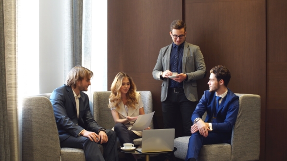 Businessmen And Businesswomen Working Together On A Document.