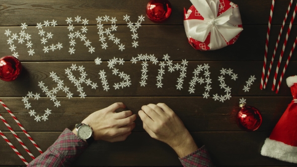 Adult Man with Watch on His Hand Sitting By Decorated Wooden New Year Table, Top Down Shot