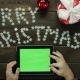 Adult Man Uses Tablet Pc with Green Screen By Christmas Decorated Desk, Top Down Shot - VideoHive Item for Sale