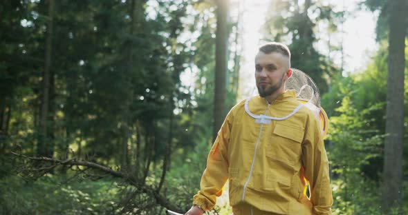 A Young Man Wearing a Yellow Jacket with a Hat That Has a Protective Net is Heading Through the