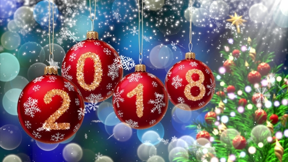 Red Balls with Numbers 2018 Hanging on the Background of a Blue Bokeh and a Rotating Christmas Tree alt