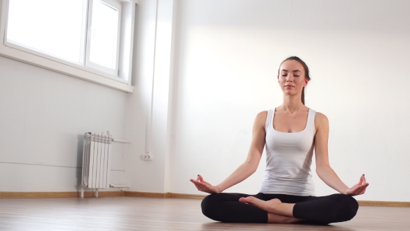 Woman Practicing Yoga in a Studio Indoors.