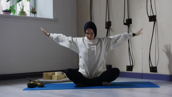 A Young Woman in Hijab Meditating and Turns Her Head to the Side