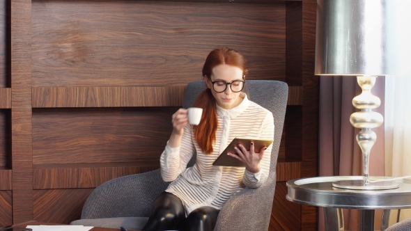 Stylish Redhead Girl Working at Home Office.