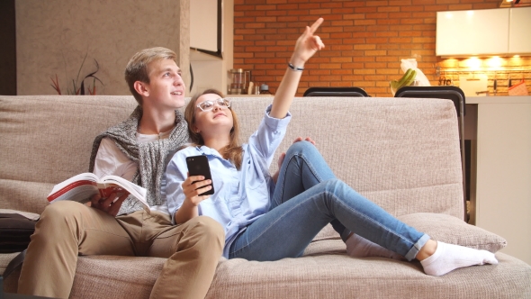 Young Loving Couple Sitting on Sofa and Plan Repair.