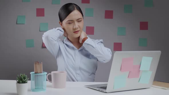 Asian woman working on a laptop was sick with body pain sitting
