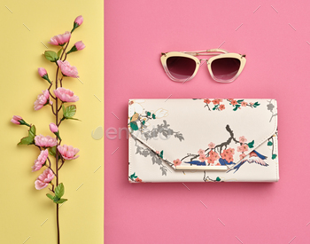 Flat lay. Minimal Style. Trendy fashion Floral Clutch, Glamour Summer Sunglasses. Blossom Flowers. Spring Floral