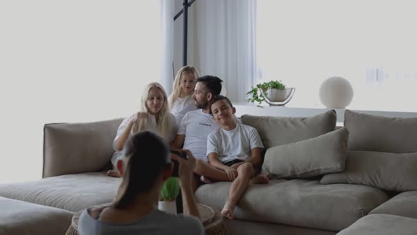 Professional Photographer Takes Pictures of Cheerful Family on Professional Camera in Living Room