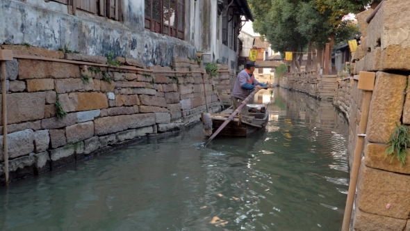 Chinese Boatman Swims Along the Canal