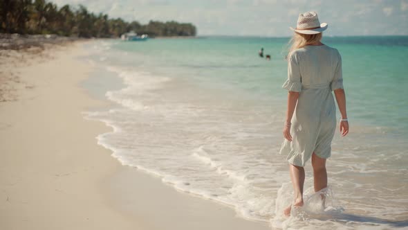 Woman Relaxing On Bahamas Flowing Dress Blowing In Wind.Travel Mood Wind Blows Dress On Ocean Resort