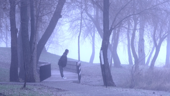 Man Doing Sport Exersises in a Misty Park