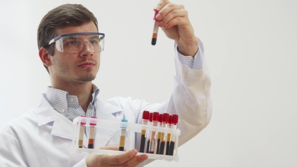 The Doctor Wearing Special Laboratory Glasses Examines Test Tubes with Blood