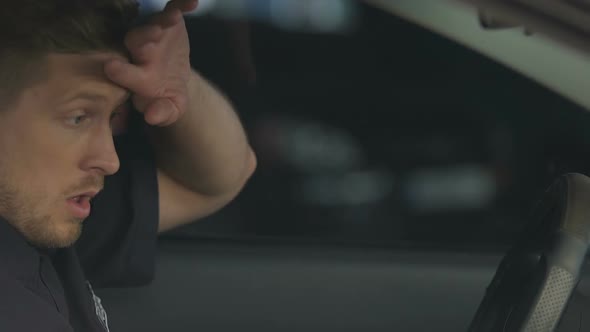 Exhausted Policeman Getting Into Patrol Car and Putting Head on Steering Wheel