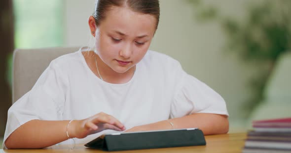 Closeup Focused Teen Girl at the Desk Scrolling Tablet First Plan and Backgroung are Blurred