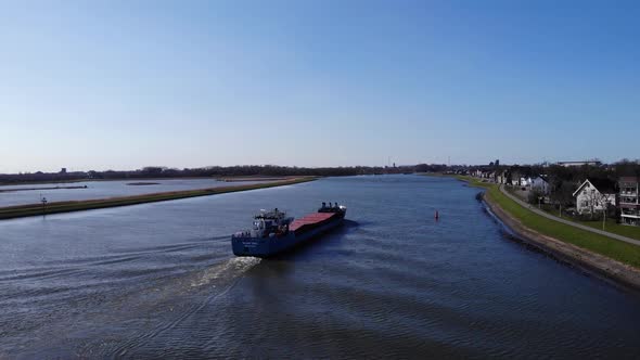 Merchant Ship Travelling Across Noord River Passing By Hendrik-Ido-Ambacht Town In South Holland, Ne