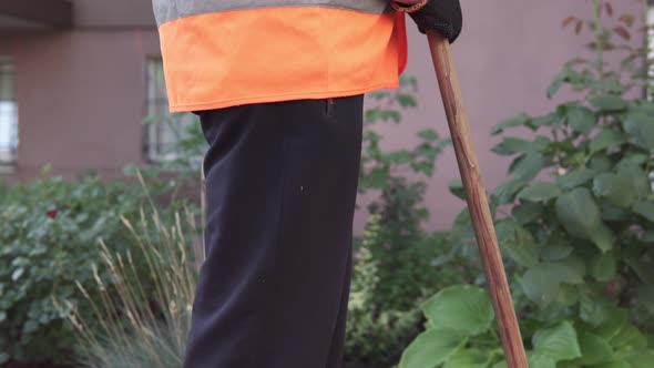 Street janitor picks up garbage. Cleanliness and order in the yard depends on the janitor.